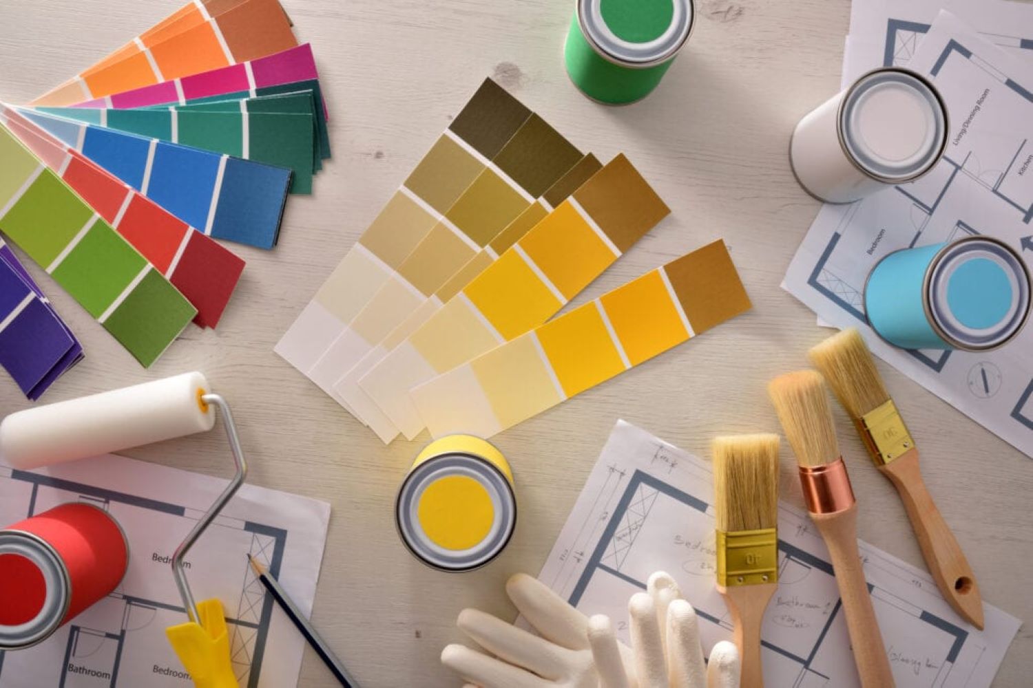 paint colour cards and paint tester pots with paint brushes on a table